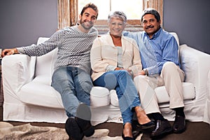 They are still the ones I run to...Portrait of a happy couple sitting with their adult son at home.