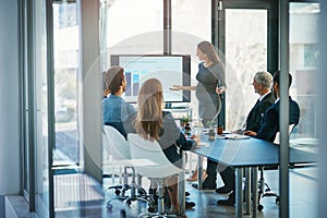 Still present and accounted for. High angle shot of a pregnant businesswoman giving a presentation in the boardroom.