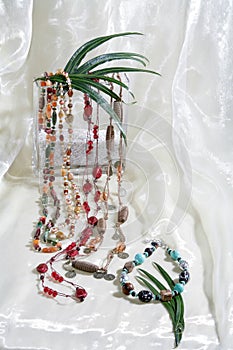 Stillife of necklace chains on white satin background photo