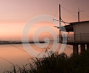 Stilt house on the sea in front of the sunset