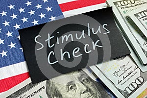Stimulus check words, money and USA flag.