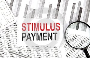 STIMULUS PAYMENT text on the paper with calculator,magnifier ,pen on the graph background