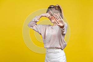 Stinky smell. Portrait of young dissatisfied woman with fair hair in casual beige blouse, isolated on yellow background