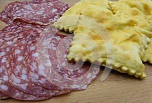 Gnocco fritto or Crescentine with slices of salami, traditional italian food from Modena or Bologna, Italy photo