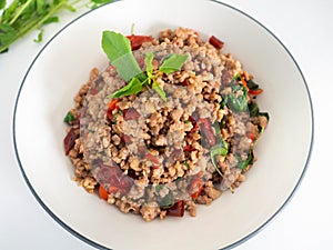 Stir fried basil with minced on a white plate,Thai food hot and spicy flavor. The ingredients are basil, garlic. Minced pork and C