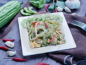 Stir-fried bitter gourd with eggs on wood background