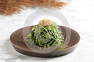 Stir-fried Cameron Highland Pea Sprout with Minced Garlic and Conpoy served in a dish isolated on grey background
