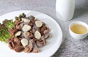 Stir-fried chicken gizzard and garlic served with alcohol.