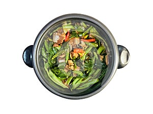 STIR FRIED CHINESE KALE WITH CANNED FISH taste spicy with chili cooking in the black pot isolated in white background.