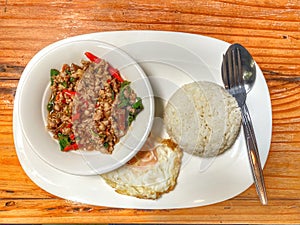 Stir fried holy basil mince pork with fried egg ate with rice. Thai asian main dish.
