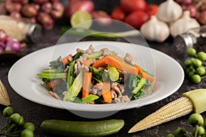 Stir fried kale and carrots with minced pork in a white plate