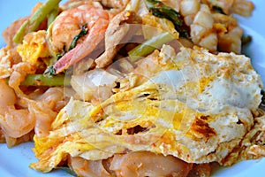 Stir fried large noodle seafood and egg with sukiyaki sauce on dish