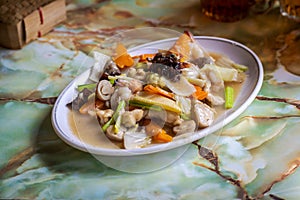 stir-fried mix vegetable carrot, wood ear mushroom, mustard greens and cabbage in white plate on dining table