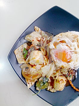 Stir Fried mixed vegetables with Roasted Chili Paste , fried egg & Thai jasmine rice on black dish. Vegetarian Food, healthy