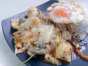 Stir Fried mixed vegetables with Roasted Chili Paste , fried egg & Thai jasmine rice on black dish. Vegetarian Food, healthy