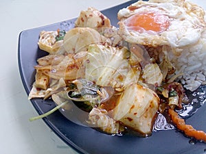 Stir Fried mixed vegetables with Roasted Chili Paste , fried egg & Thai jasmine rice on black dish. Vegetarian Food, healthy