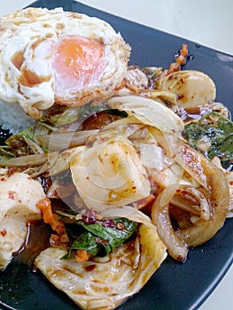 Stir Fried mixed vegetables with Roasted Chili Paste , fried egg & Thai jasmine rice on black dish. Vegetarian Food, healthy