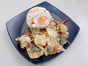 Stir Fried mixed vegetables with Roasted Chili Paste , fried egg & Thai jasmine rice on black dish. Vegetarian Food, healthy