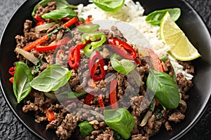 Stir Fried Pad Kra Pao with rice in black bowl