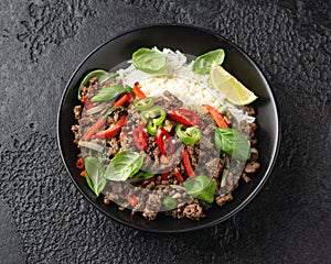 Stir Fried Pad Kra Pao with rice in black bowl