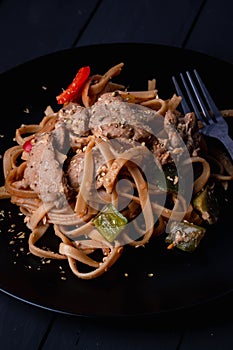 Stir-fried pasta with pork in black dish