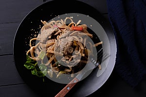 Stir-fried pasta with pork in black dish