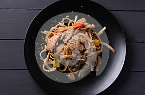 Stir-fried pasta with pork in black dish