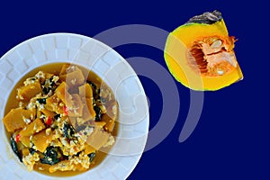 Stir fried pumpkin with egg and basil isolated on blue background