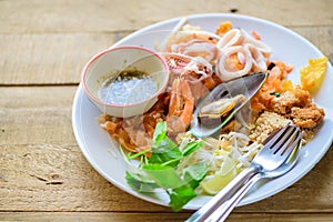 Stir-fried rice noodles Pad Thai with shrimp, mussels and squid