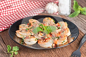 Stir-fried Shrimp with pepper and garlic on black plate.