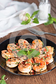 Stir-fried Shrimp with pepper and garlic on black plate.