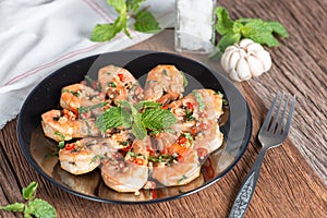 Stir-fried Shrimp with pepper and garlic on black plate.