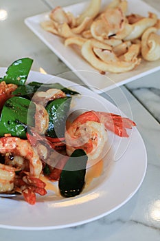 Stir Fried Shrimp or prawns with Chili and kaffir lime leaves on white plate.