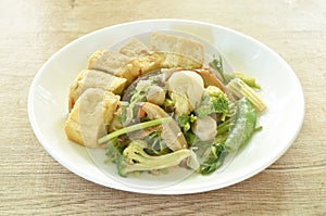 stir fried slice cabbage broccoli with green pea and straw mushroom couple dice tofu in soy sauce vegetarian food on plate