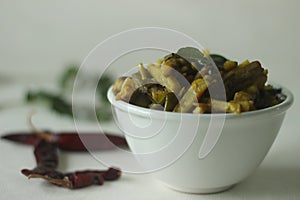 Stir fried small raw banana slices with shallots and spices. The raw banana slices are thin and long. Popular side dish for meals