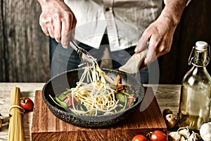 Stir-fried spaghetti with assorted vegetables - traditional italian recipe - selective focus - desaturated effect