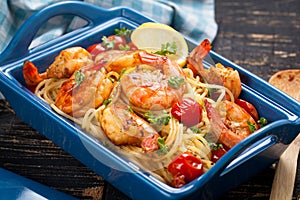 Stir-fried spaghetti with grilled shrimps and tomatoes - Italian fusion food style.