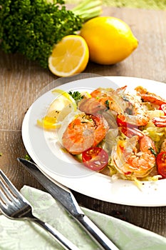 Stir-fried spaghetti with grilled shrimps and tomatoes - Italian fusion food style.