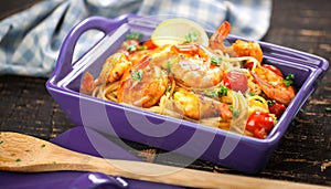 Stir-fried spaghetti with grilled shrimps and tomatoes - Italian fusion food style.