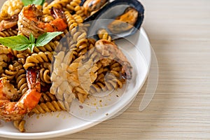 Stir-fried spiral pasta with seafood and basil sauce