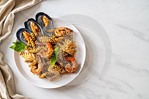 Stir-fried spiral pasta with seafood and basil sauce