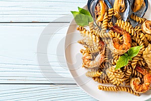 Stir-fried spiral pasta with seafood and basil sauce