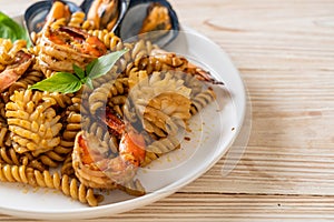 Stir-fried spiral pasta with seafood and basil sauce