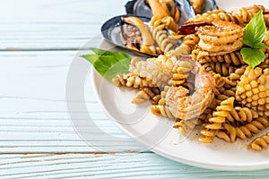 Stir-fried spiral pasta with seafood and basil sauce