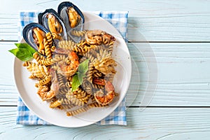 Stir-fried spiral pasta with seafood and basil sauce