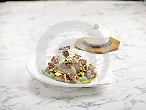 Stir-fried US Angus Beef with Bitter Gourd in Black Bean Sauce served in a plate side view on grey marble background USA Food