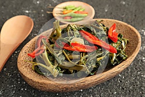 Stir fried water spinach or cah kangkung. Traditional asian indonesian food, cooked veggies, spicy vegetable dish for vegan,