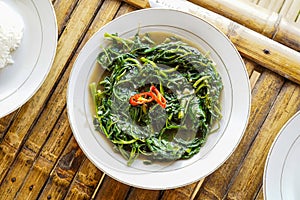 Stir-fried Water Spinach, Morning Glory, Stir-fried Kale, tumis kangkung served on a white plate