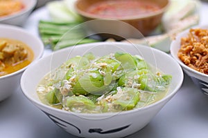 stir-fried zucchini with eggs in a white dish in a bowl on the set of group plates Thai food. Top view.