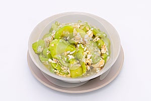 stir-fried zucchini with eggs in a white dish on a white isolated background. Thai food. Top view.